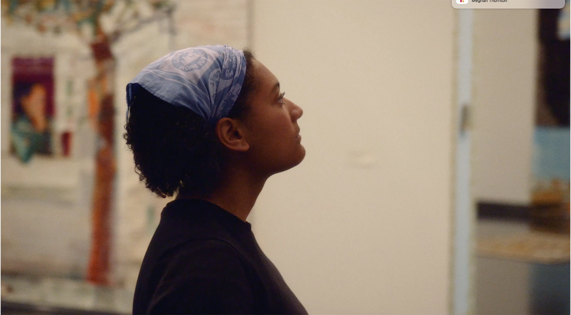 Still of a young woman looking at a piece of art