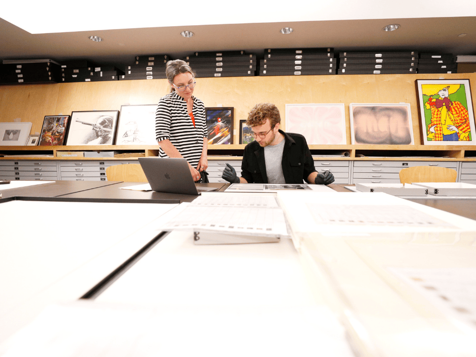 Skidmore College student Evan Little, the 2020-21 Charina Endowment Fund Intern at the Tang Teaching Museum, looks at photographs with Associate Curator Rebecca McNamara as part of a research project related to work in the Tang collection