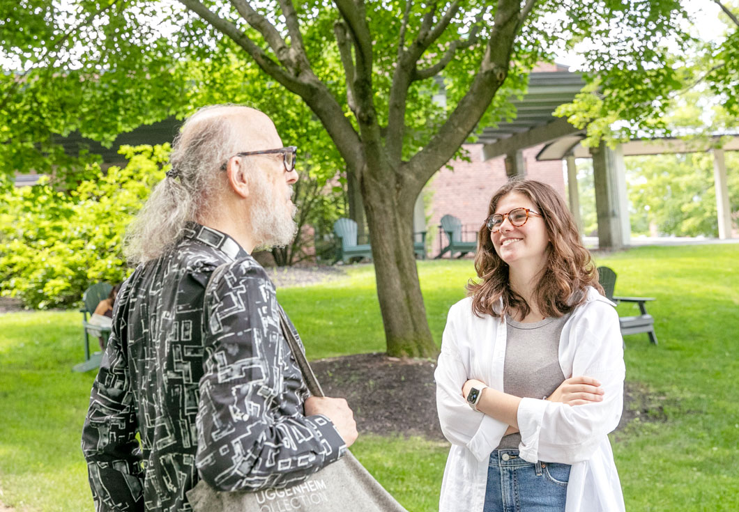 Skidmore College student Charlotte Mahn '25 talks with professor of English Robert Boyers on campus