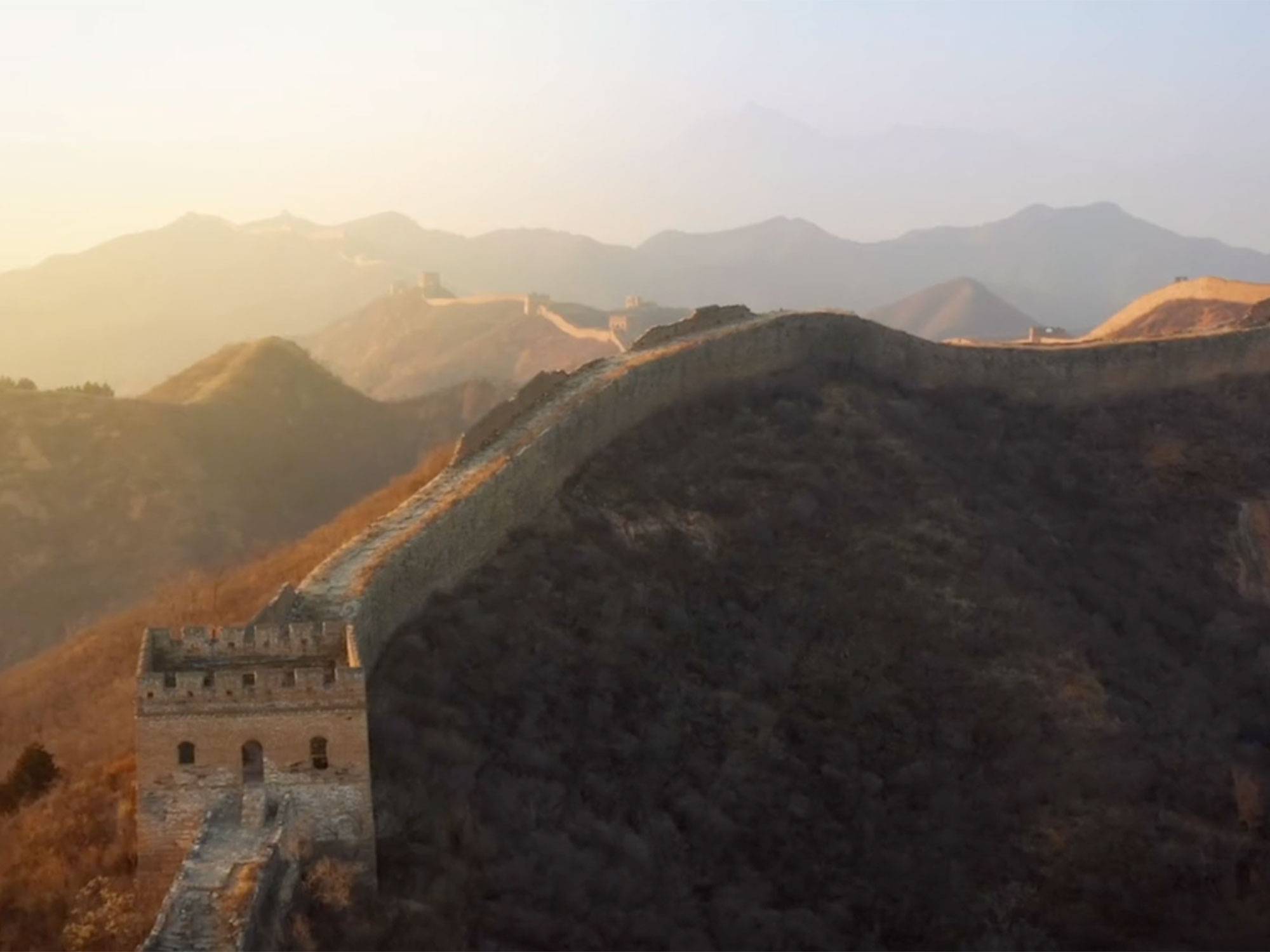 The Great Wall of China with the sun beginning to set in the background