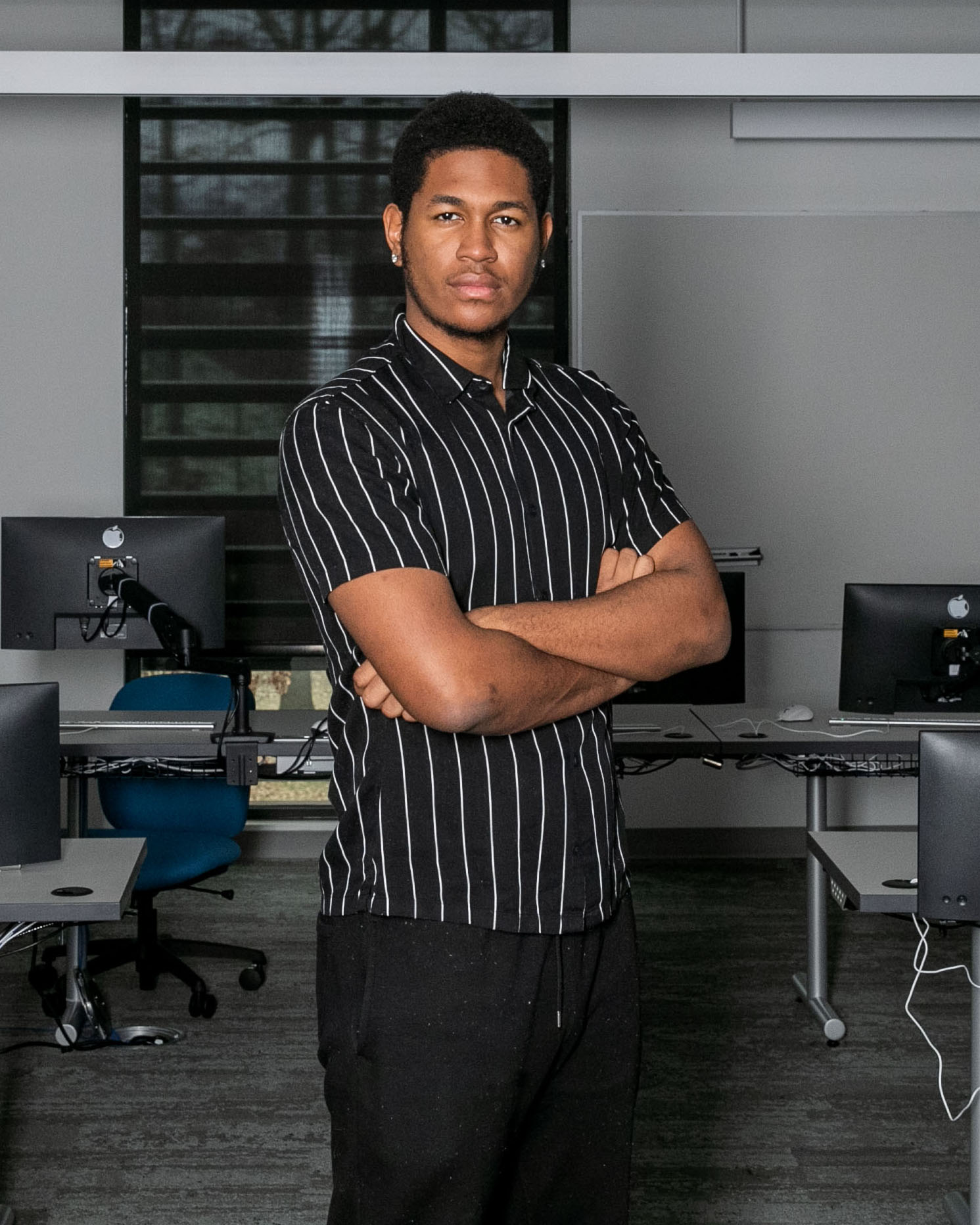 Giovanni Peyo ’24 stands in front of a classroom in BTCIS.