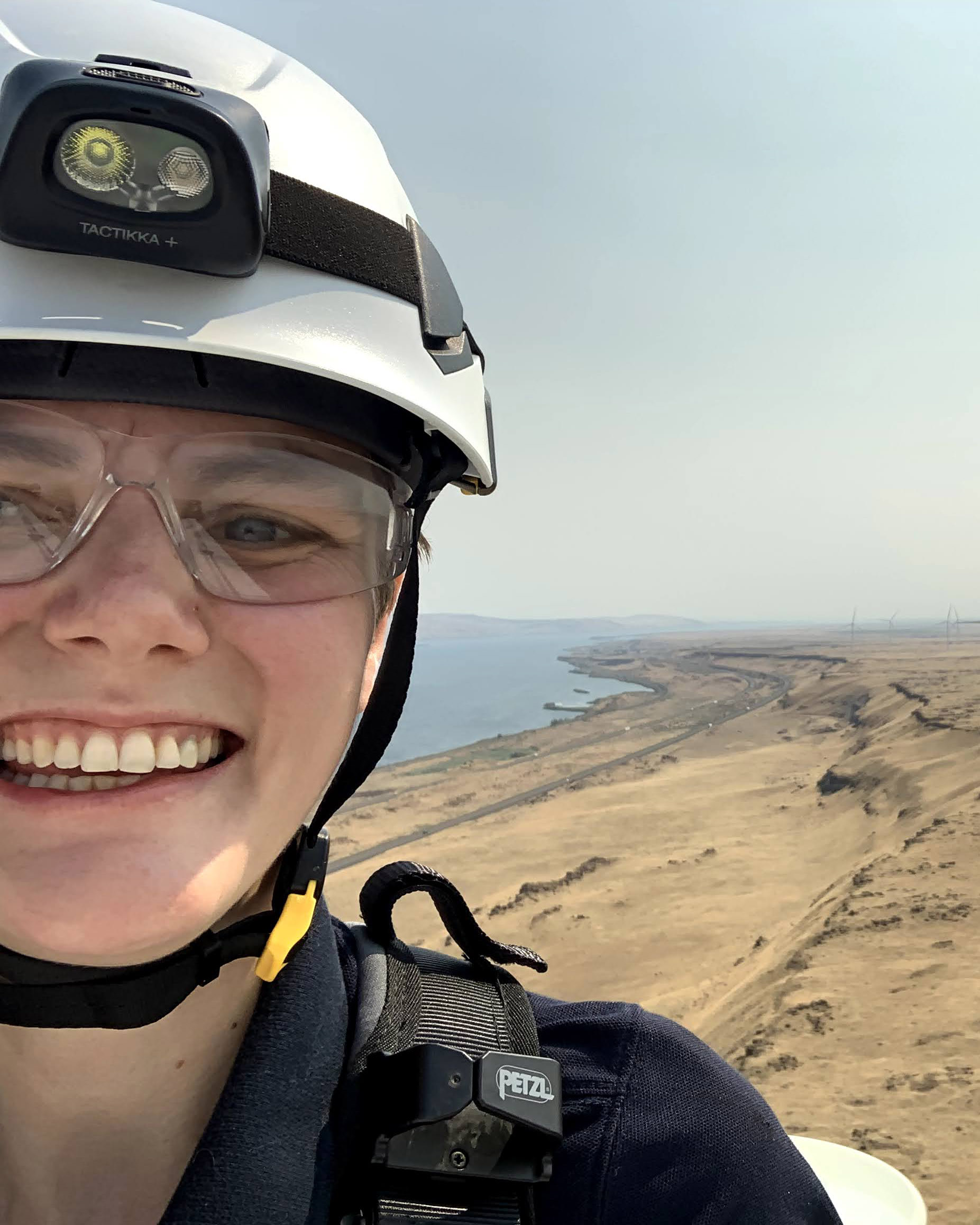 Pauline Searles ’15 smiles from the top of a windmill. Other windmills can be seen in the background.