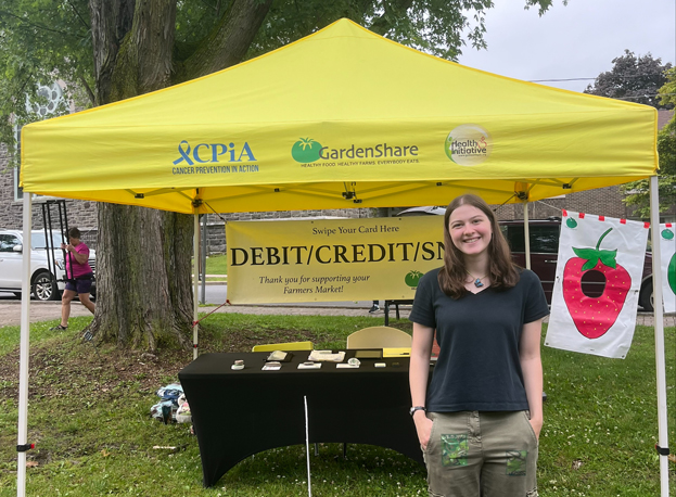 Caroline Ettinger-DeLong ’26 paints a child's face at GardenShare in St. Lawrence County, New York