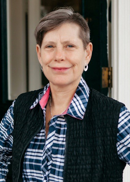 Katherine “Kath” Gross smiles at the camera, wearing a blue flannel.