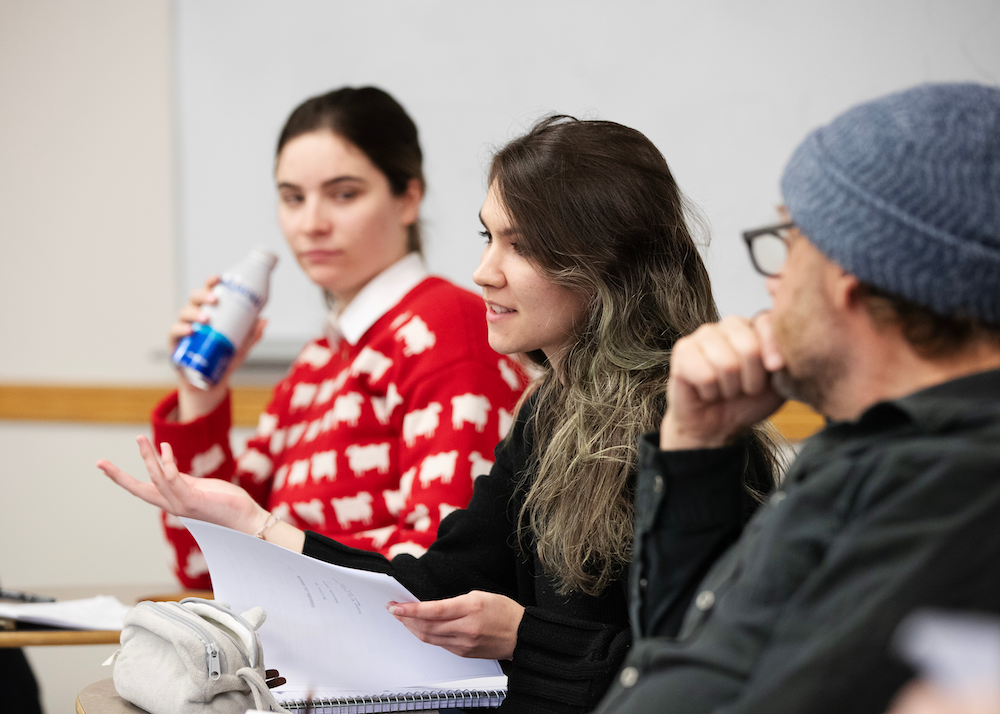 Ingrid Johnson ’25 lifts a page from her screen play and speaks during Zicherman's visit to the MF 351 Advanced Screenwriting course.