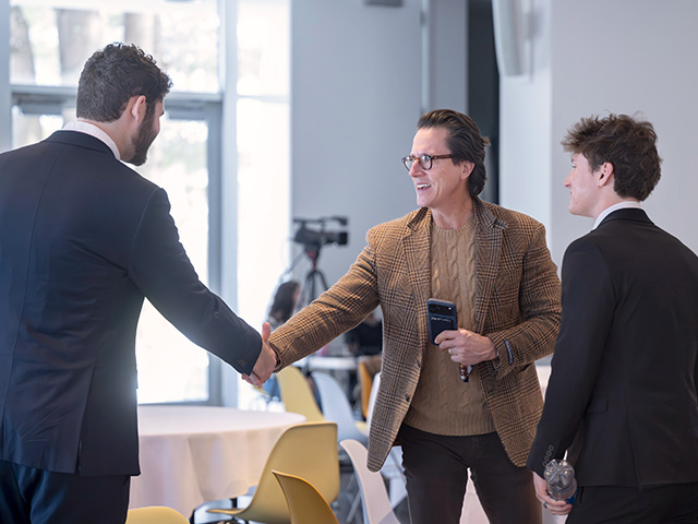 Bill Caleo ’99 (center), co-founder of The Brooklyn Home Company, who served as a judge, shakes hands with Milo Flamenbaum ’26 (left) and Tom Fuller '26 of Rally, which placed third. 