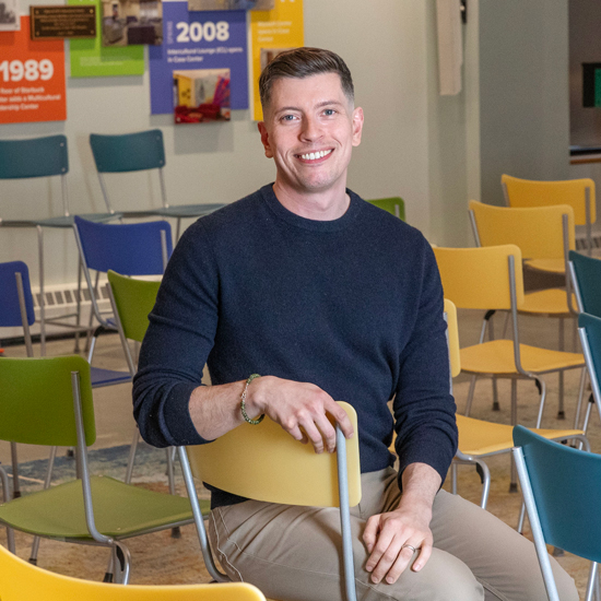 Fred Braunstein ’08 sits in a chair in Skidmore's Wyckoff Center