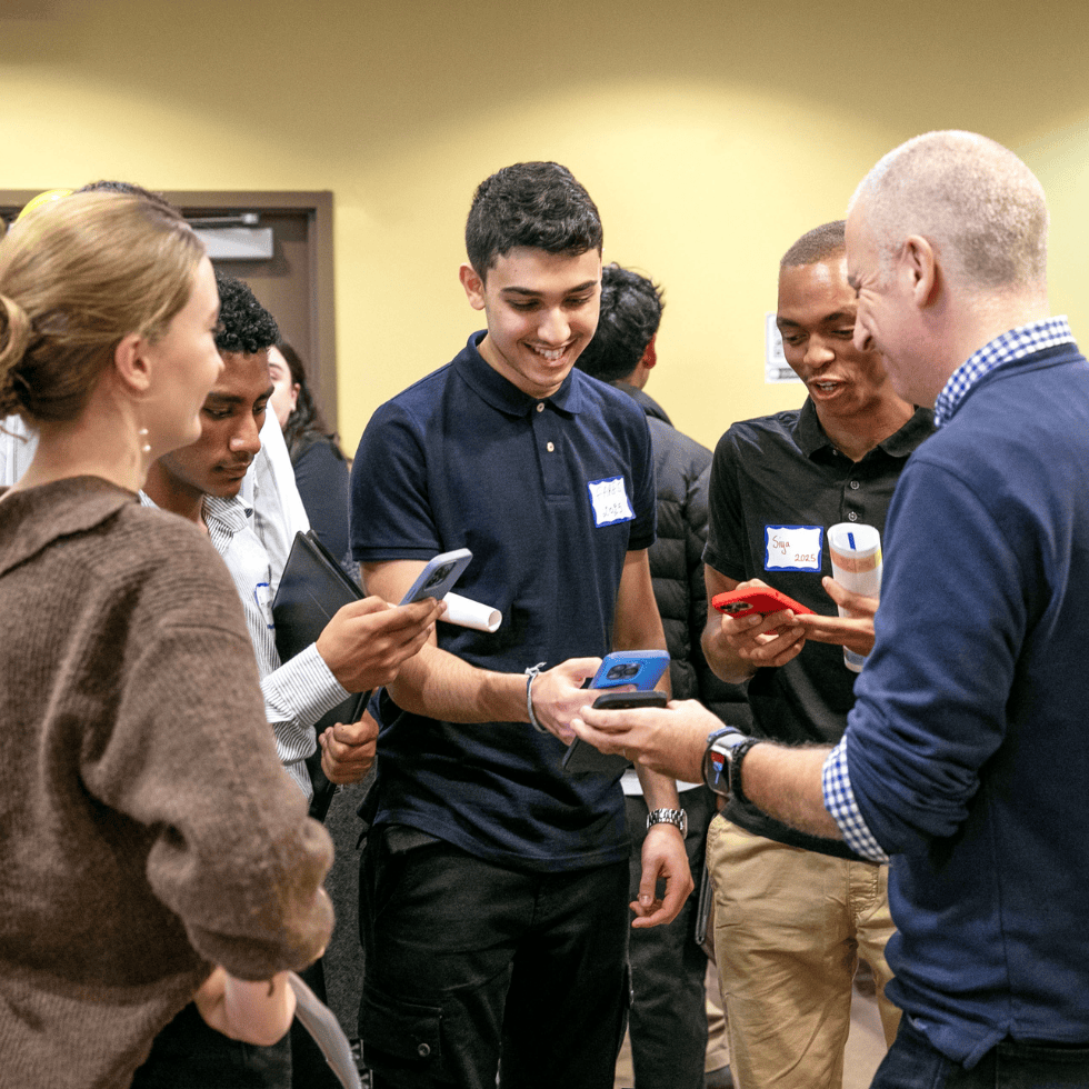 A parent interacts with 3 students during career jam.