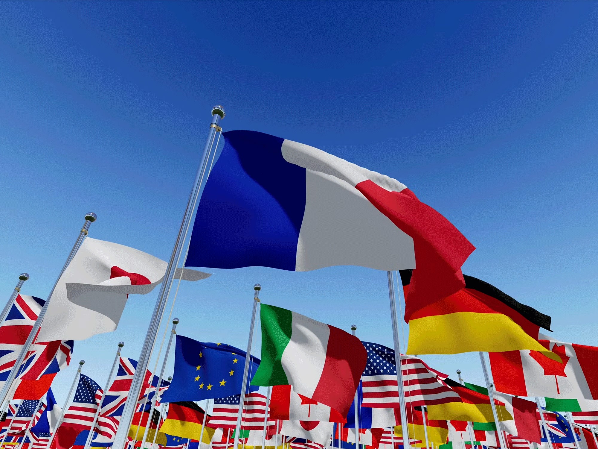 Various countries flags flying with a blue sky in the background
